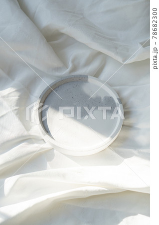 Empty round tray on white textured linen background, designer jewelry plate Empty round tray on white textured linen background, designer jewelry plate 78682300