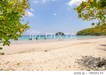 Empty tropical summer beach background Green trees leaves frame with blue sky and white sand beach Wave crashing on sandy shore Amazing beach at Phuket Thailand. 78684134