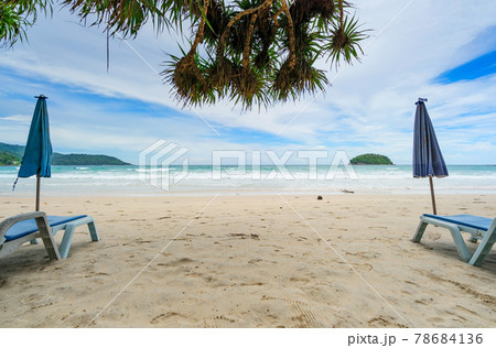 Summer sandy beach with beach chair and wave seafoam clashing on sandy shore turquoise ocean water and blue sky white clouds over sea Natural background for summer vacation Travel website. 78684136