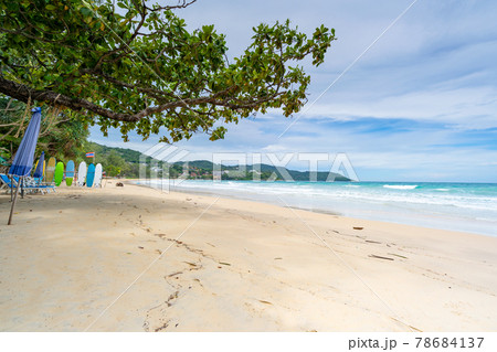 Summer sandy beach with beach chair and wave seafoam clashing on sandy shore turquoise ocean water and blue sky white clouds over sea Natural background for summer vacation Travel website. 78684137