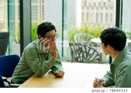 作業服にネクタイ姿の会社員の内緒話 78684542