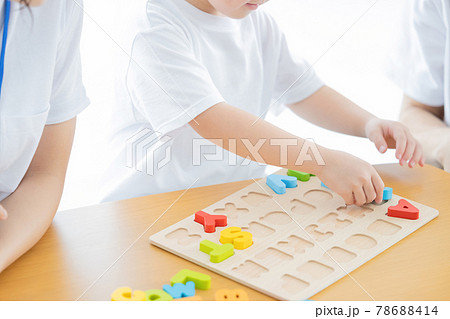 幼児教室　英語学習　アルファベットのブロックを型にはめる子供の手元 78688414