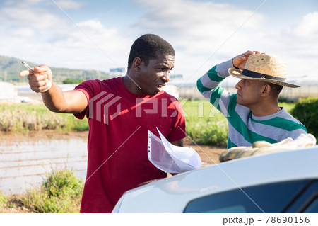 Disgruntled african american farmer reprimanding hispanic contractor Disgruntled african american farmer reprimanding hispanic contractor 78690156