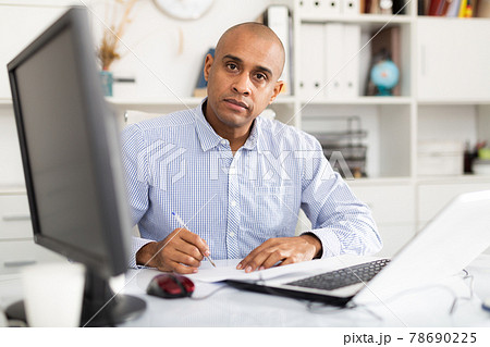 Adult businessman working in office with laptop, sitting at desk Adult businessman working in office with laptop, sitting at desk 78690225