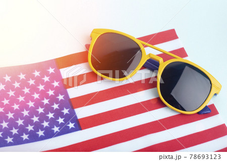 Summer sunglasses on the USA flag and colored background. Vacation, summer, sun and USA vacation concept. Summer sunglasses on the USA flag and colored background. Vacation, summer, sun and USA vacation concept. 78693123