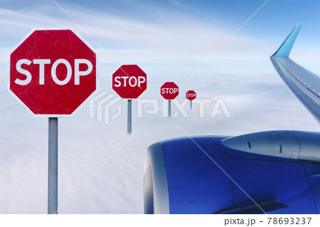 Flight ban and closed borders for tourists and travelers. No-fly zone concept. Airplane in flight with a STOP sign Flight ban and closed borders for tourists and travelers. No-fly zone concept. Airplane in flight with a STOP sign 78693237