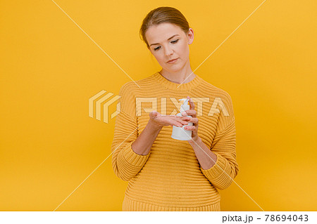 Beautiful pretty woman casually dressed uses an antiseptic sanitizer or liquid soap on her hand , looks on hands, having doubtful expression , Hygiene, cleaning concept standing isolated against a Beautiful pretty woman casually dressed uses an antiseptic sanitizer or liquid soap on her hand , looks on hands, having doubtful expression , Hygiene, cleaning concept standing isolated against a 78694043