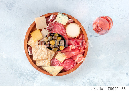 Charcuterie and cheese board, shot from above with a glass of rose wine Charcuterie and cheese board, shot from above with a glass of rose wine 78695123
