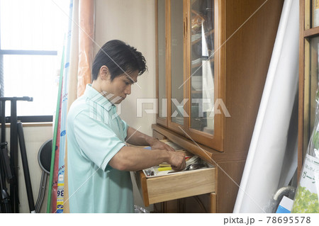 散らかった部屋と片付ける作業員 78695578