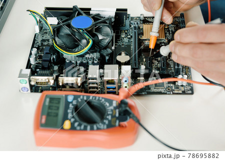 A technician checks the serviceability of the computer motherboard. 78695882