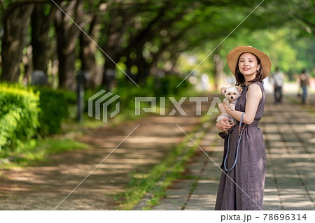 小型犬と一緒に散歩する若い女性　柏の葉公園　桜のトンネル 78696314