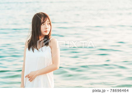 海に入るワンピースの女性 の写真素材
