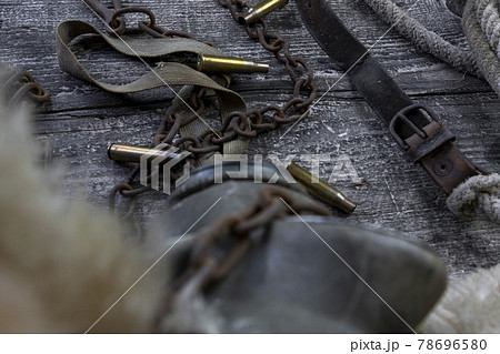 Bullet caings and rusy chain resting on wooden table 78696580