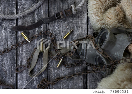 Bullet caings and rusy chain resting on wooden table Bullet caings and rusy chain resting on wooden table 78696581