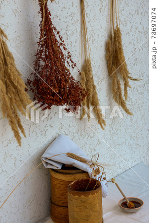 Medicinal herbs and birch bark boxes against a white wall 78697074