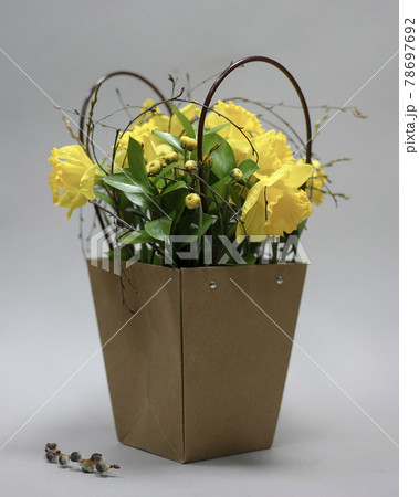 Bouquet of tulips in a decorative paper basket on a white background 78697692