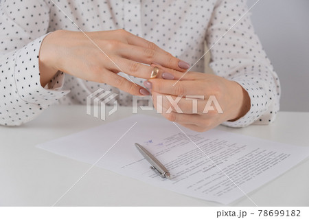 Close-up woman signed divorce papers and took off her wedding ring Close-up woman signed divorce papers and took off her wedding ring 78699182
