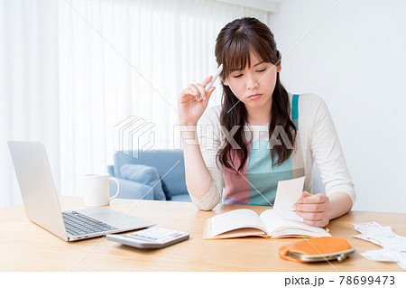 レシートを確認しながら家計簿をつけ家計のやりくりに悩む女性 78699473