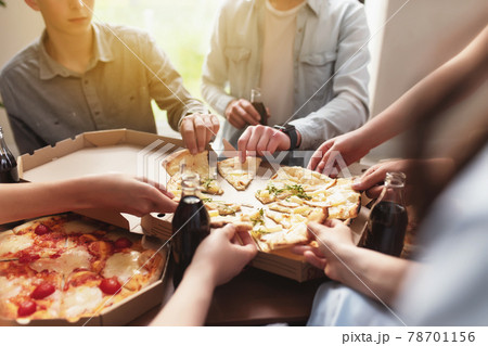Pizza party, group of friends chatting, eating pizza, drinking sweet soda water Pizza party, group of friends chatting, eating pizza, drinking sweet soda water 78701156