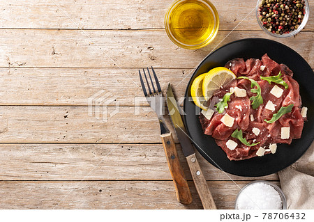 Marbled beef carpaccio on black plate 78706432