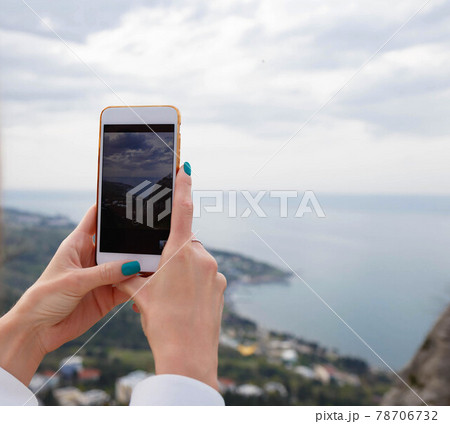 close-up photography. female hands taking pictures of the sea on the phone 78706732