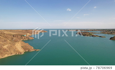 Flying over a lake with islands and rocks. 78706969