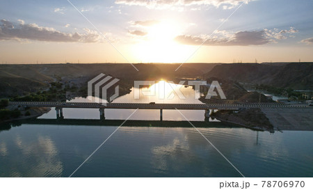 Sunset with a view of the dam and bridge. 78706970