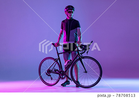 Cyclist riding a bicycle isolated against neon background 78708513