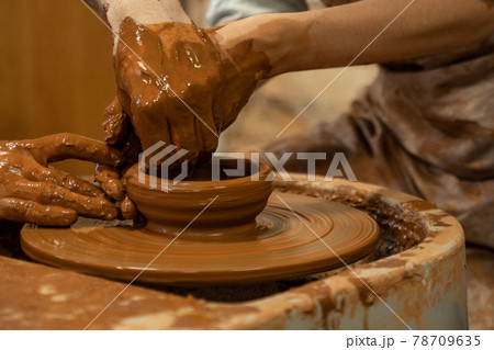 Hands of the skilled master Potter and woman hands, training of the woman to production of pottery on a Potter wheel 78709635
