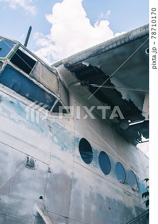Close-up of a crashed airplane wing. The metal frame and internal parts are visible. Pieces of upholstery and fabric upholstery blow in the wind. Rust and debris 78710170