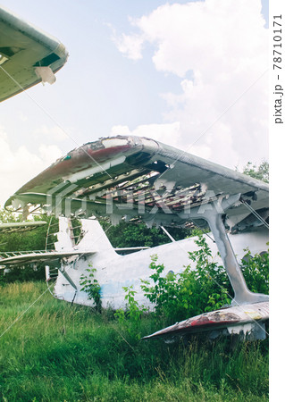 Close-up of a crashed airplane wing. The metal frame and internal parts are visible. Pieces of upholstery and fabric upholstery blow in the wind. Rust and debris Close-up of a crashed airplane wing. The metal frame and internal parts are visible. Pieces of upholstery and fabric upholstery blow in the wind. Rust and debris 78710171