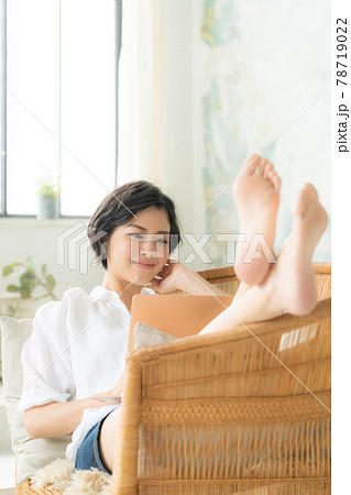 椅子の上でパソコンを使う若い女性 78719022