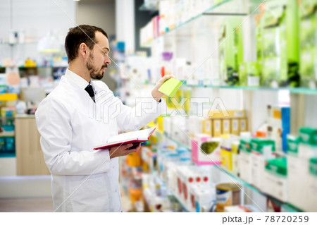 Male pharmacist checking assortment of drugs Male pharmacist checking assortment of drugs 78720259