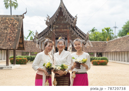 Portrait of group of Asian Shan women girls, Tai Yai, northern Thai people with traditional Lanna clothes holding flowers at Wat Ton Kwen temple, lanterns decoration. Culture lifestyle. 78720738
