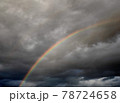 雨上がり、黒い雲に鮮やかな虹 78724658