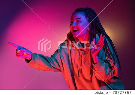 Young woman's portrait on gradient colors studio background in neon. Concept of human emotions. Young woman's portrait on gradient colors studio background in neon. Concept of human emotions. 78727367