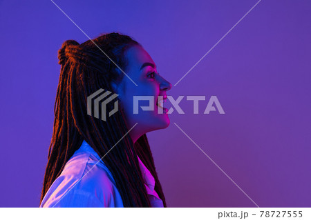 Young woman's portrait on gradient colors studio background in neon. Concept of human emotions. 78727555