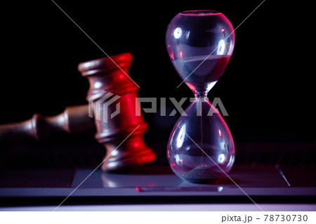 Judge's gavel, scales of justice and hourglass on laptop close-up 78730730
