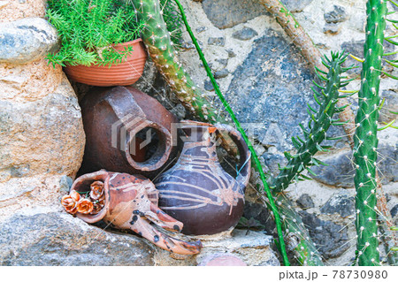 Large vintage decorative clay pots stand on stonework with green flowers Large vintage decorative clay pots stand on stonework with green flowers 78730980
