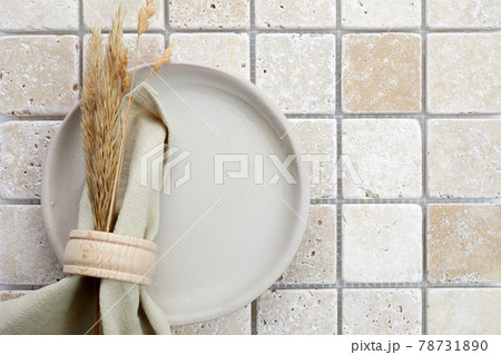 Stylish serving on a travertine mosaic background. Linen napkin on plate. Top view Stylish serving on a travertine mosaic background. Linen napkin on plate. Top view 78731890