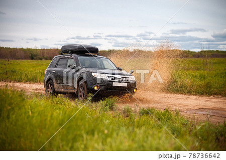 Black Subaru Forester moving at dirty forest road making a lot of water splashes 78736642