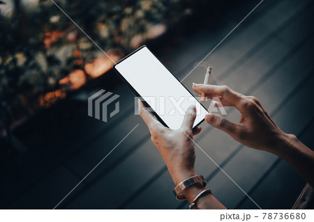 Woman's hands and smartphone with cigarettes. Woman's hands and smartphone with cigarettes. 78736680