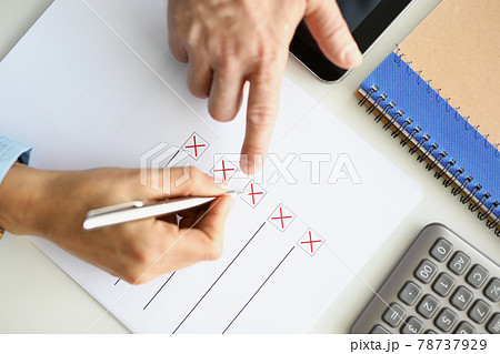 Man and woman filling out questionnaire on desktop closeup 78737929