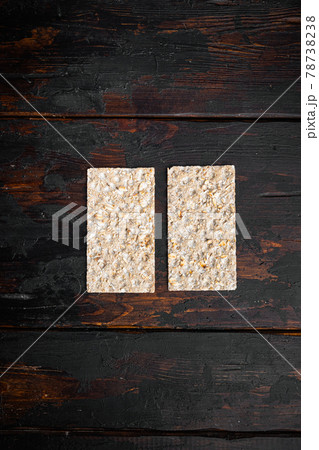 Crispbread with sunflower, chia and sesames seeds, on old dark wooden table background, top view flat lay, with copy space for text 78738238