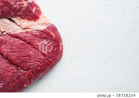 Raw brisket beef cut. Black Angus beef, on white stone background, top view flat lay, with copy space for text Raw brisket beef cut. Black Angus beef, on white stone background, top view flat lay, with copy space for text 78738254