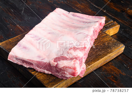 Raw Pork ribs, on wooden cutting board, on old dark wooden table background Raw Pork ribs, on wooden cutting board, on old dark wooden table background 78738257