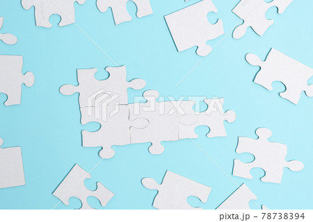 Close-Up White Jigsaw Pattern Puzzle Pieces To Be Connected With Missing Last Piece Positioned On A Flat Lay Background With Different Texture And Paper Supplies Accesories Close-Up White Jigsaw Pattern Puzzle Pieces To Be Connected With Missing Last Piece Positioned On A Flat Lay Background With Different Texture And Paper Supplies Accesories 78738394