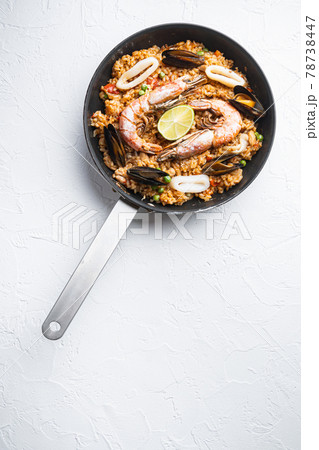Paella cooked in frying pan on white textured background, flat lay with copy space 78738447