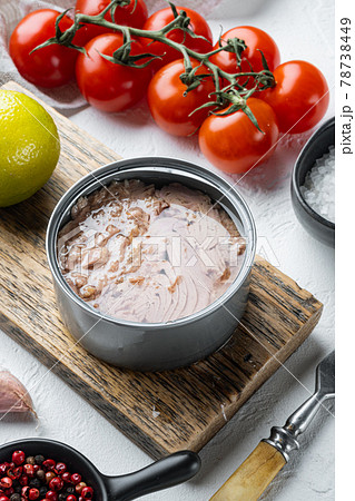 Canned Wild Yellowfin Tuna, on wooden cutting board, on white background with herbs and ingredients 78738449