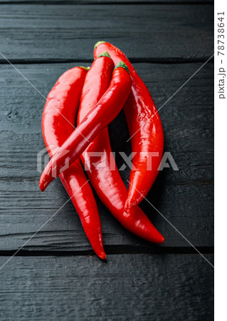 Raw red chili pepper, on black wooden table 78738641